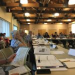 People at a conference studying paper files