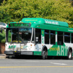 A green and white ART bus on the road